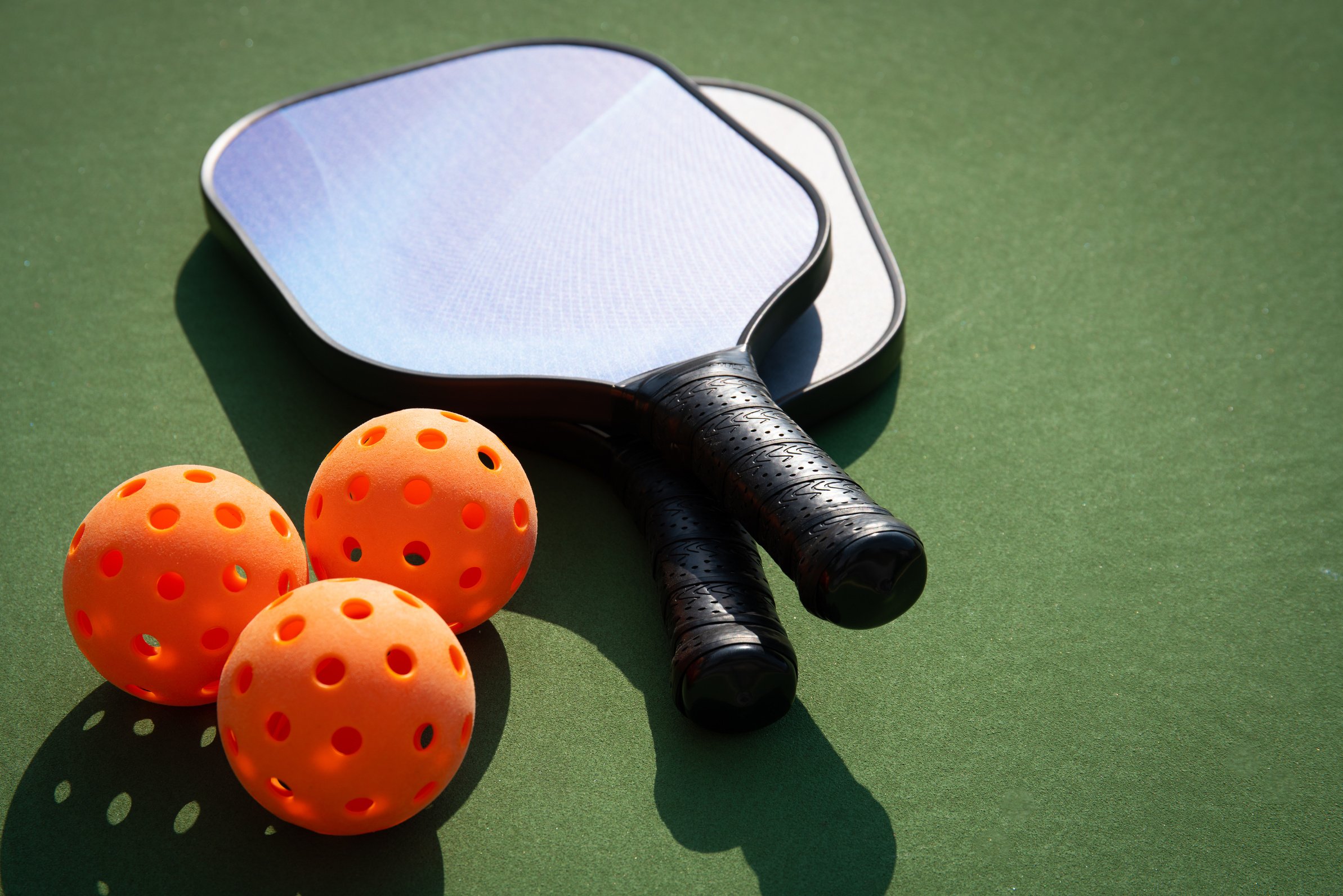 Pickleball and paddle on court